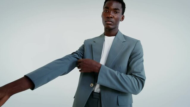 A man in a business suit and sneakers on a white background