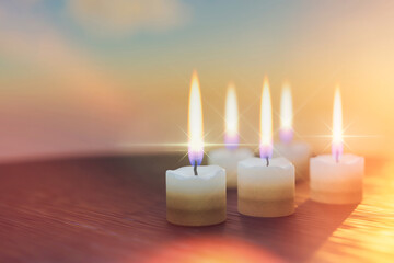five wax thick short candles burn on a wooden table. religious holiday ritual, cleansing, meditation