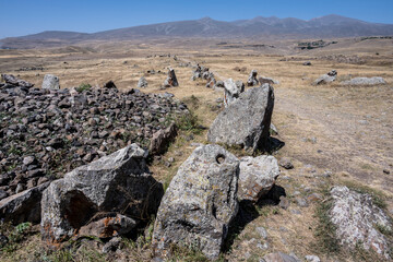 ancient stone observatory against the background of yellow hills in the mountains of Armenia