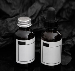 Close up of two phase copper peptides dropper bottles  on black background.