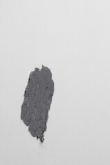 Black smear texture on whitye background. Cosmetics mud mask, gray clay product texture on a white background.