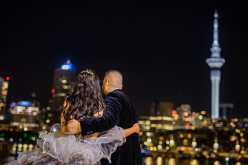 Indian couple's embracing each other back view night city skyline