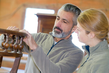 man and woman looking at antique furniture