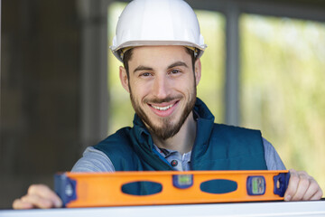 happy smiling constructor holding tool