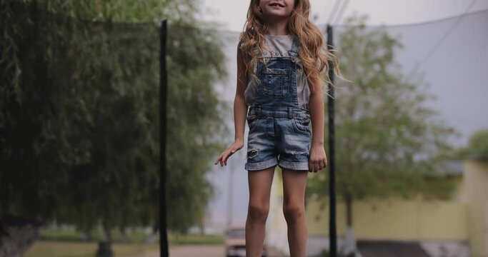 Little girl jumping on a trampoline, slow motion