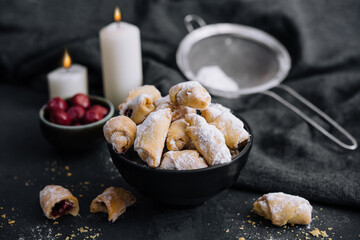 Homemade fresh cookies dusted powdered sugar in black plate