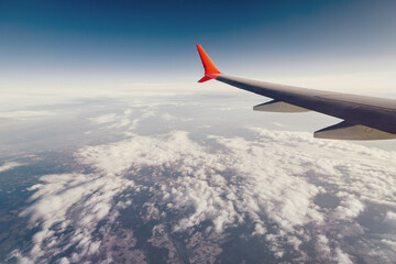 Obraz premium Airplane wing view from the window during a flight on vacation or on business. Beautiful sky and curved winglet for fuel economy