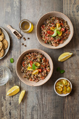 Assiette de salade taboulé aux lentilles, quinoa et crudités sur table
