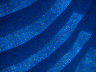 View of stairs leading to a swimming pool. Mosaic pattern tiles.