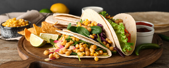 Board with tasty vegetarian tacos on table