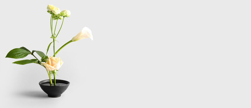 Beautiful ikebana on light background with space for text