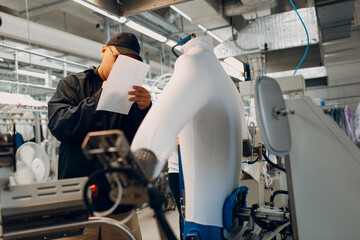 Worker working on Iron Dryer Mannequin steamer at Dry cleaning clothes. Clean cloth chemical process. Laundry industrial dry-cleaning.