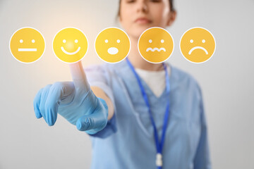 Female doctor pointing at smiling emoticon on virtual screen, closeup