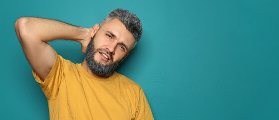 Portrait of cool handsome man with dyed hair and beard on color background with space for text