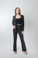Full length body portrait of a young beautiful asian female businesswoman wearing full black business attire and pose with different gestures & emotions. Suitable for business presentation or slides.