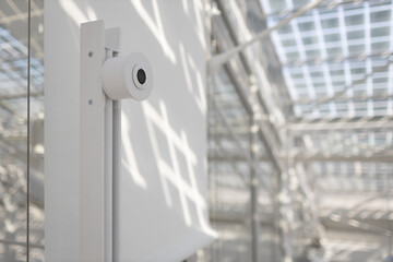 Face recognition system with camera in front of office in white interior indoor door