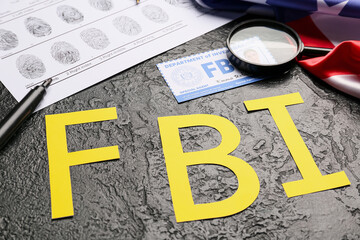 Abbreviation FBI with magnifier, finger prints and document of agent on dark background