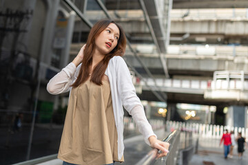 Lifestyle portrait photo of a beautiful young asian lady relax and posing around the city after a long pandemic lockdown