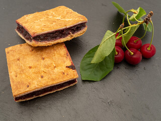 fresh homemade sour cherry pie and sour cherries on slate	
