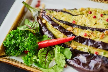 Fried eggplant with melted cheese, spices, herbs and pepper. A dish from a restaurant