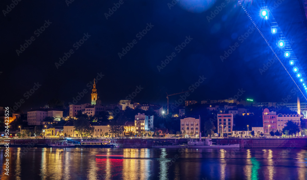 Wall mural View of the historical city center and the Sava river in Belgrade, capital of Serbia at night. Shot with glares and bokeh