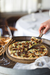 Mushroom pizza on a wooden board. Serving pizza. The chef cuts the pizza. A piece of pizza on a spatula.