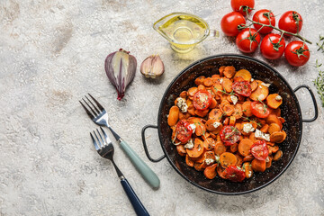 Composition with frying pan of baked vegetables and ingredients on light background
