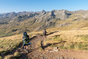 Fototapeta premium Hikers descending towards Anéou. Ossau Valley