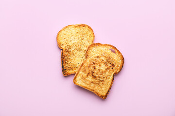 Slices of tasty toasted bread on pink background