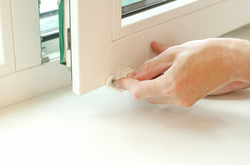 Obraz premium Close-up of male hands installing roller blinds on the window. Installation of roller blinds