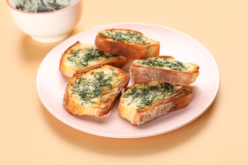 Plate with slices of toasted garlic bread with dill on color background