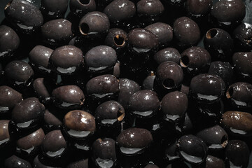 Texture of tasty black olives as background, closeup