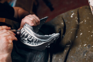 Artisan craftsman create mask based on plaster cast. Gypsum mold and plastic mask sculpting.