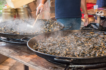 Cuisson des moules dans deux grandes poêles