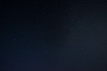 Bezchmurne nocne niebo, głęboka czerń pokryta gwiazdami.