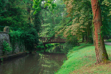 Drewniany, w stylu japońskim most dla pieszych w parku dworskim w mieście Iłowa w zachodniej...