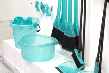 Cleaning inventory. House cleaning equipment shovel brush bucket broom blue basin on a white rack....