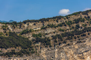 Wooded mountain top and rock wall on the northern shore of Lake Garda in Italy