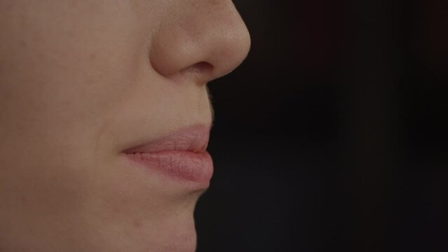 Close up side view of a young adult caucasian woman mouth talking in slow motion