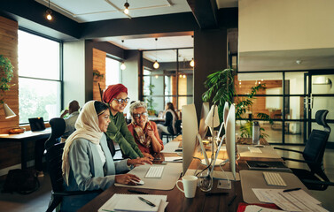 Group of ethnic businesswomen working together in a coworking office - obrazy, fototapety, plakaty