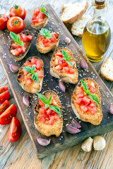 Classiche bruschette con pomodoro fresco, basilico e olio extravergine di oliva - cibo italiano 