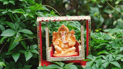 Lord Ganesha idol sitting in decorated swing in Ganesh Chaturthi festival in India. The Elephant...