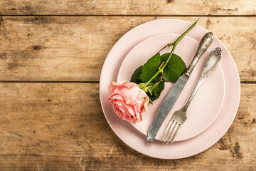 Romantic dinner table on rustic background. Love cutlery for Valentine's or Mother's day, Wedding