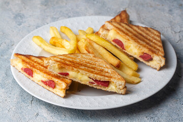 Turkish toast, mixed toast with cheddar cheese, sausage and ham, with fried potatoes (Turkish name; Karisik tost)