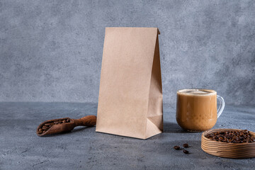 Coffee identity branding mockup. Blank brown craft bag with coffee beans and cup of coffee. Package mockup template for logo, brand, sticker, label.