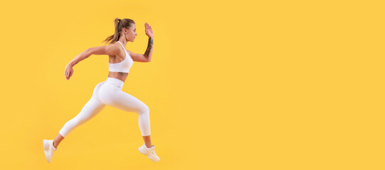 Fototapeta na wymiar active sport girl runner running on yellow background. Woman jumping running banner with mock up copyspace.