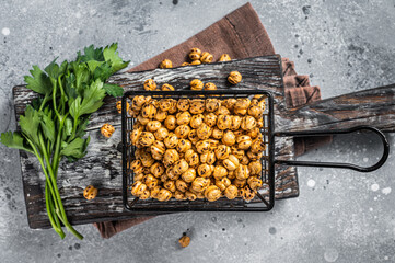 Healthy snack roasted spicy chickpeas in a basket. Gray background. Top view