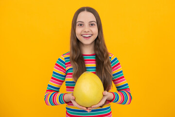 Teenager child girl hold citrus fruit pummelo or pomelo full of vitamin. Kid healthy eating.