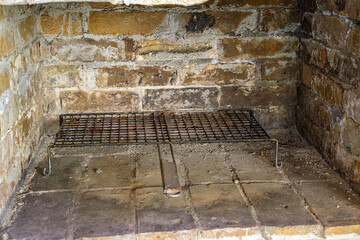 stone fireplace with metal grill ready to make BBQ