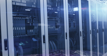 Image of binary coding numbers changing over tech room with computer servers